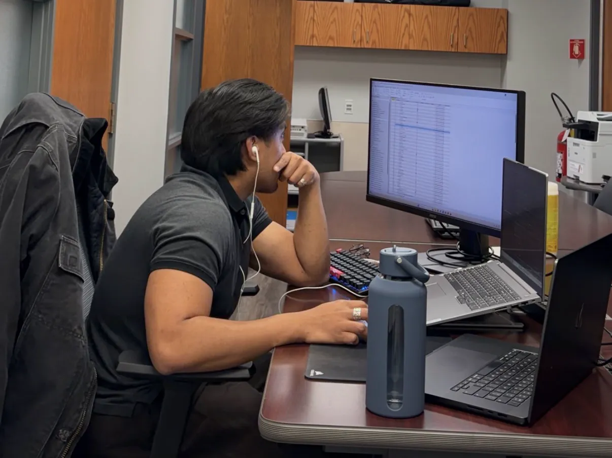 Working at a desk with a monitor and two laptops