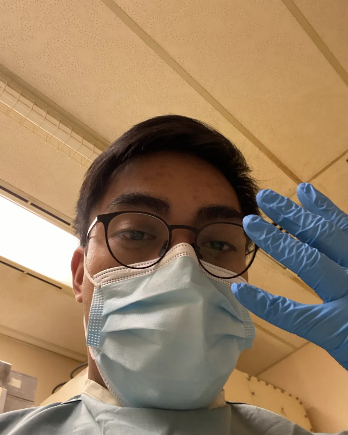 Mark in a surgical mask, gown and blue gloves in the lab